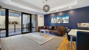Ein modernes Wohnzimmer mit einer Couch, einem Couchtisch und einem Essbereich mit Tisch und Stühlen.