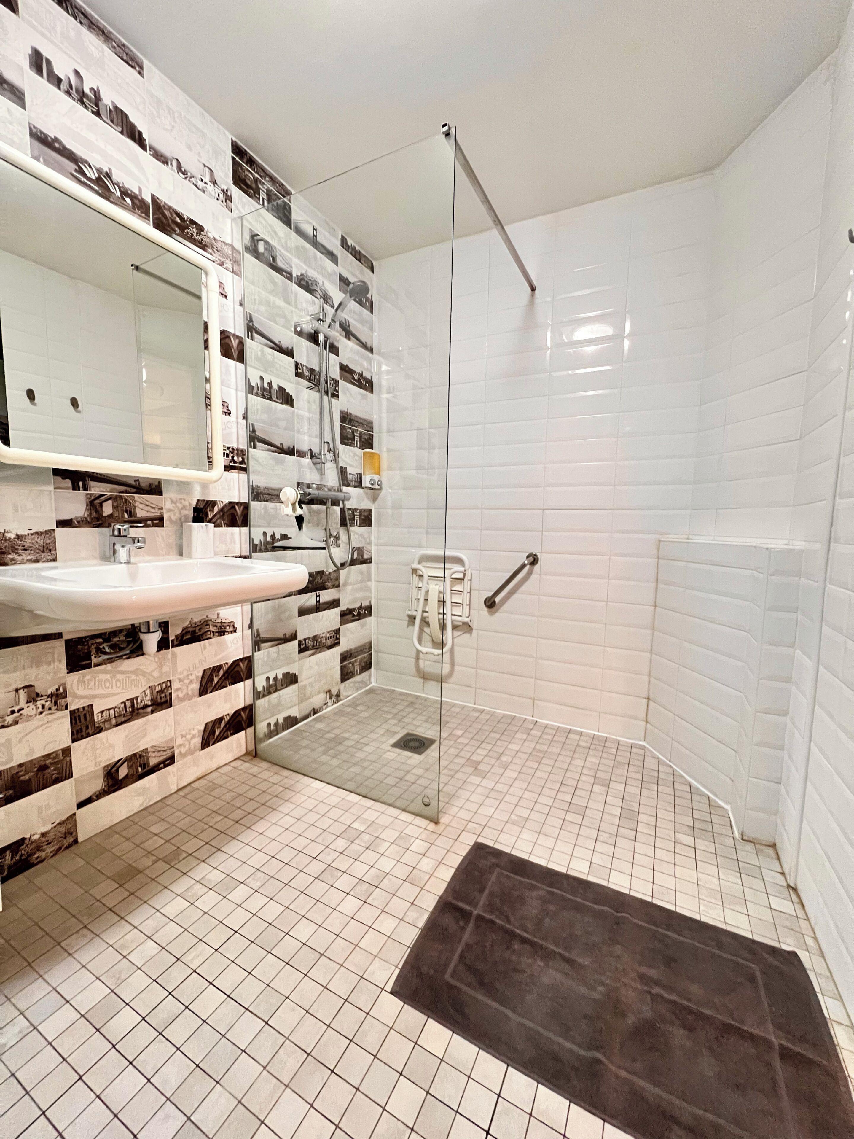 Een badkamer met een douche, een wastafel en een spiegel.