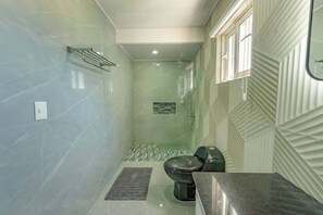 Ein Badezimmer mit Dusche, Toilette und Waschbecken.