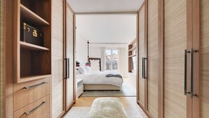 Ein Schlafzimmer mit Bett, Nachttischen, einem Kleiderschrank und einer Bank.