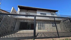 A two-story building with a metal fence in the foreground. - Hospedaria Campinas  (Campinas)