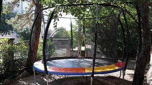 A trampoline in a covered area surrounded by trees. - Holiday apartment with air conditioning and garden (Jadranovo)