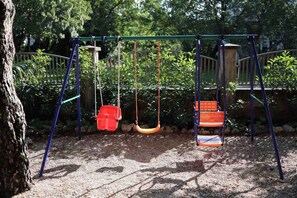 A playground with swings and a climbing structure. - Holiday flat pleasantly overlooking the courtyard and garden (Jadranovo)