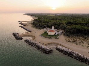 Eine Küstenlandschaft mit Leuchtturm, Strand und Felsen.