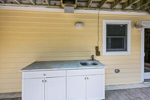 A small kitchen with a sink, cabinets, and a window. - Northshore Lookout: Golf & Beach Retreat (Nags Head)