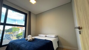 Een slaapkamer met een bed, een raam en een deur.