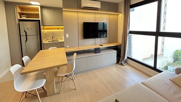 Een moderne keuken met een ingebouwde televisie, een eethoek met stoelen en een groot raam met uitzicht.