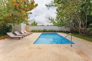 A rectangular swimming pool with a metal ladder, surrounded by beige tiles. - Luxurious 3 Bedroom Villa With Private Pool in Sosua Ocean Village (Sosúa)