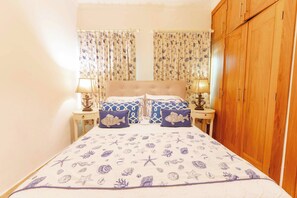 A bedroom with a bed, curtains, bedside tables, and a wardrobe. - Luxurious 3 Bedroom Villa With Private Pool in Sosua Ocean Village (Sosúa)