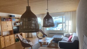 Ein gemütliches Wohnzimmer mit Holzmöbeln, einem Fernseher und einem Bücherregal.