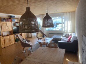 A cozy living room with wooden furniture, a television, and a bookshelf. - Feriensiedlung Trü 23, (Scuol) by Interhome (Scuol)