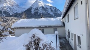Ein schneebedecktes Gebäude mit Blick auf verschneite Berge.