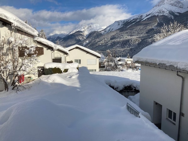 A residential area with snow-covered roofs and mountains in the background. - Feriensiedlung Trü 23, (Scuol) by Interhome (Scuol)
