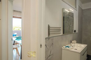 A bathroom with a white sink, a towel rack, and a mirror with a tree design. - The Breath of the Sea - Alghero (Alghero)