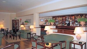 Een hal met zitplaatsen, een bar en een receptiebalie.