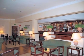 A lobby with seating, a bar area, and a reception desk. - Jardim Hotel (Santo Tirso)