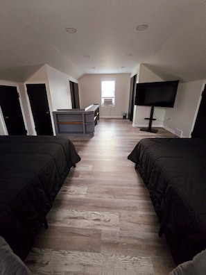 A room with two beds, a desk, a TV, and a window. - Fully Furnished Insurance Housing 3BR Home (Detroit)