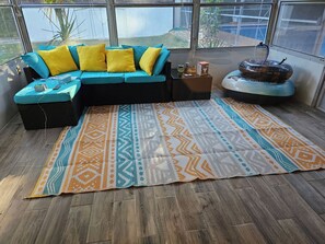 Ein Zimmer mit Ecksofa, einem gemusterten Teppich und einer Wasserspiele.
