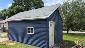 A small, single-story building with a gabled roof, a front door, and a small window. - MedCity Suite—2BR/1BA Near Mayo Clinic (Rochester)
