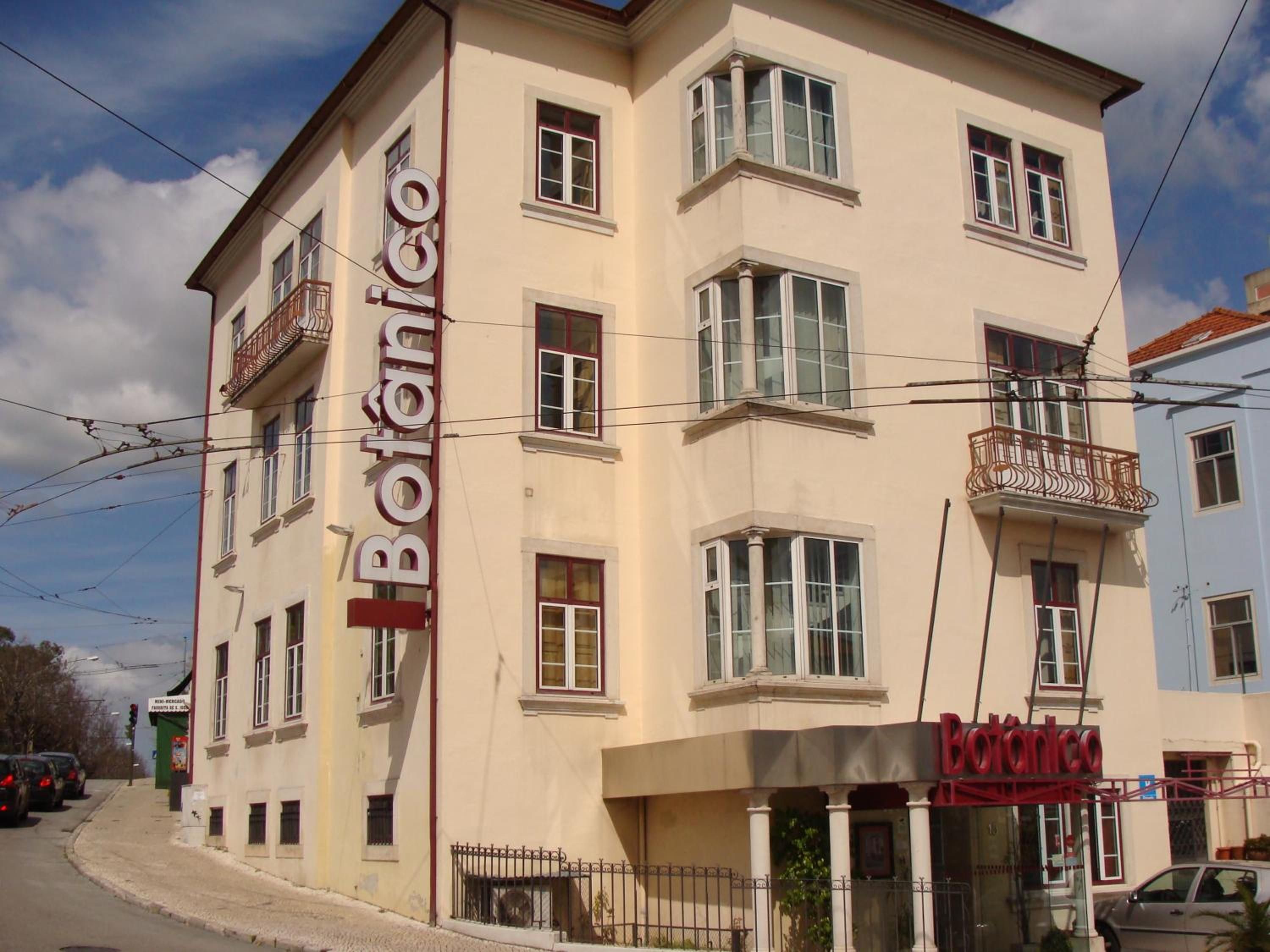 Um edifício de vários andares com uma placa na fachada que diz 'Botanico'.