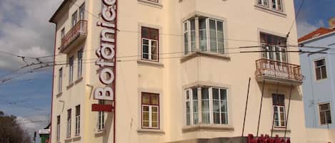 Um edifício de vários andares com uma placa na fachada que diz 'Botanico'.