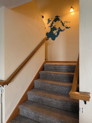 A staircase with wooden handrails and carpeted steps.