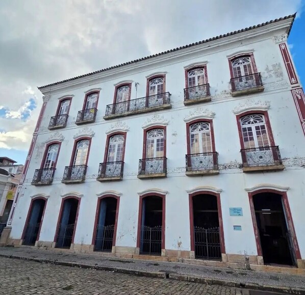 Un edificio blanco con numerosas ventanas y balcones, que presenta un estilo arquitectónico tradicional.