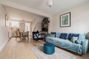 Un salon moderne avec un canapé, une table à manger et un escalier menant à un autre niveau.