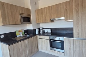 Eine moderne Küche mit Holzausstattung, einer Mikrowelle, einem Toaster und einem Backofen.