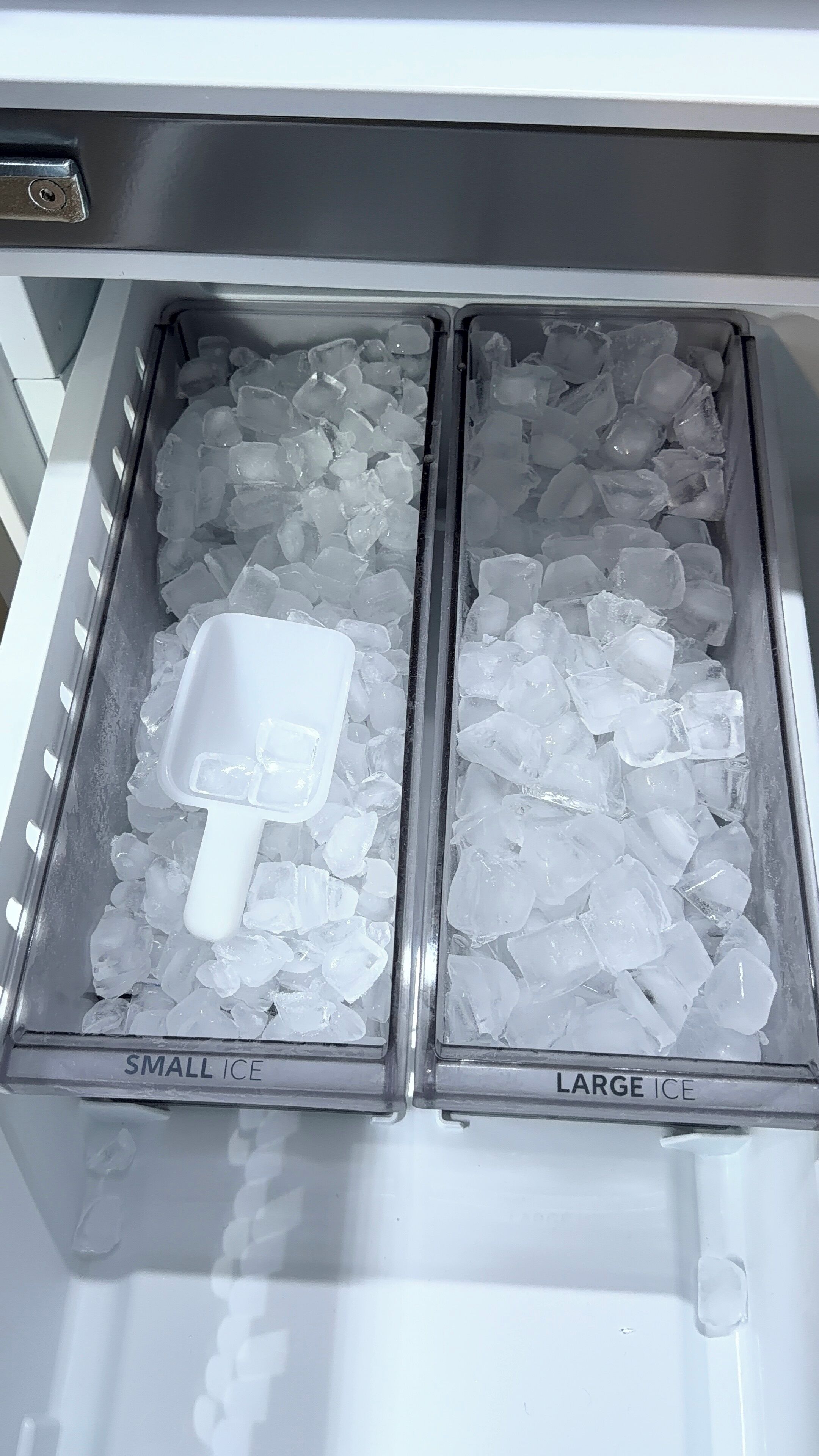 A freezer with two compartments labeled 'SMALL ICE' and 'LARGE ICE,' containing ice cubes and a scoop.