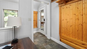 A hallway with a wooden door labeled 'CANDAL CREEST,' a window with a lamp, and a stone-tiled floor. - Candal Crest in Tamarack (Big Creek)