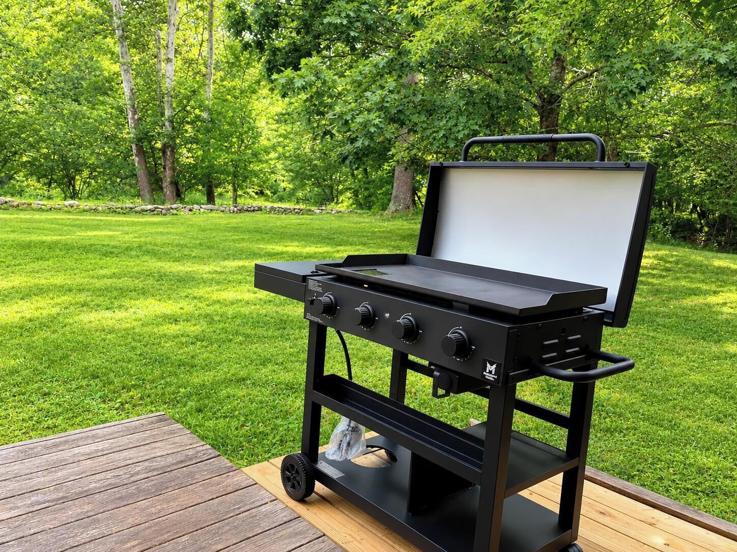 Ein tragbarer Grill mit Bedienfeld und weißem Deckel, auf einer Holzterrasse platziert.