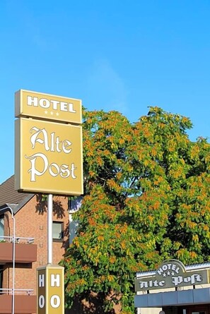 A hotel sign with 'HOTEL Alte Post' and a building with a similar sign. - Alte Post (Krefeld)