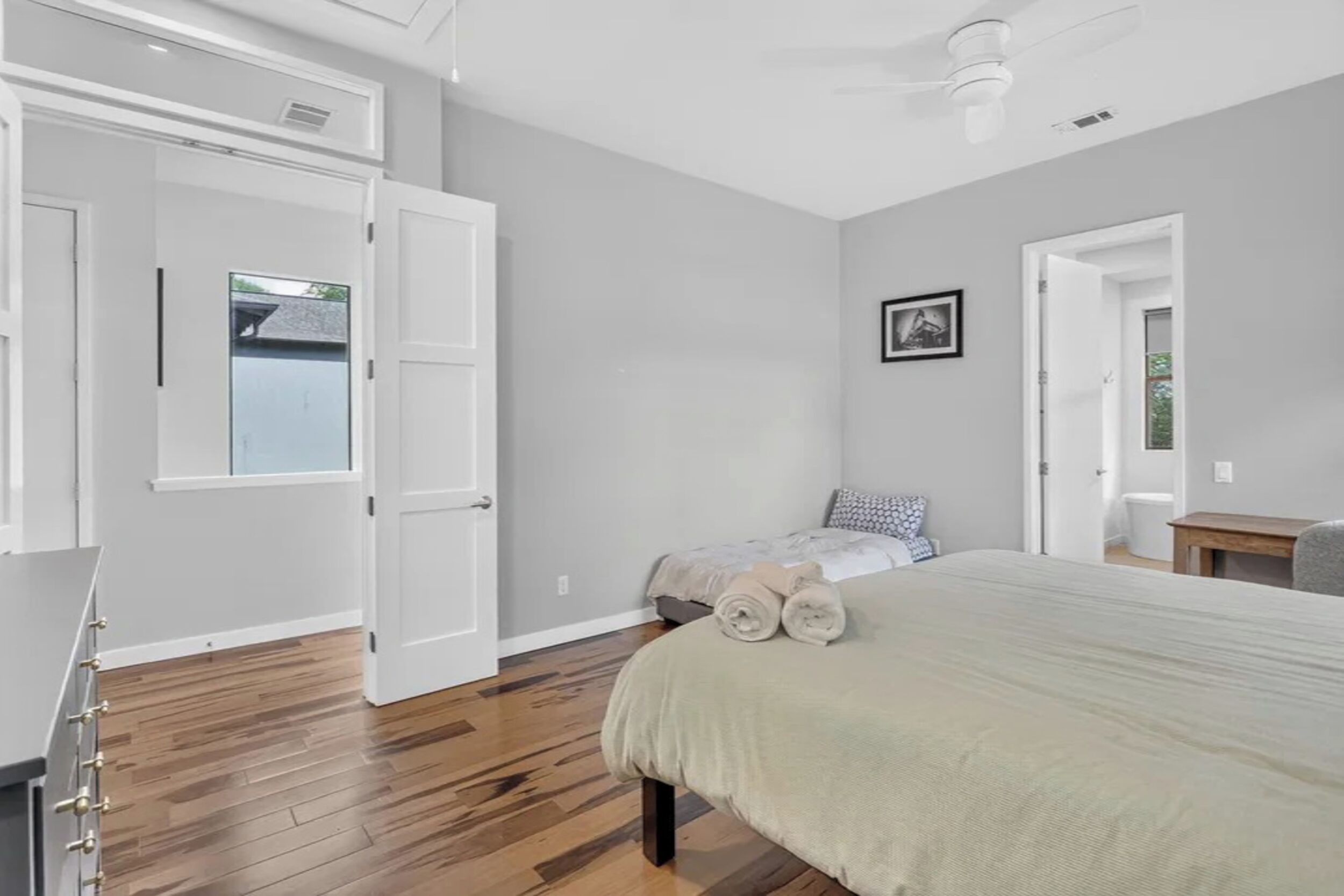 Un dormitorio con una cama, un escritorio y una silla.
