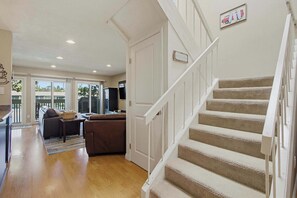 Ein geräumiger Wohnbereich mit Treppe, Sofa und Couchtisch.