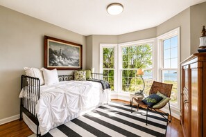 A bedroom with a bed, a chair, a window, and a painting on the wall. - Tranquil 4-bedroom house with beautiful views in charming Lancaster (Lancaster)