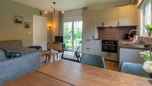 Una cucina moderna con zona pranzo, TV e vista sull'esterno.