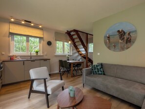 Ein stilvoller Wohnraum mit Küche, Essbereich und Treppe.