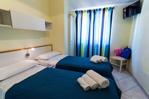 A hotel room with two beds, a TV mounted on the wall, and a window with colorful curtains. - Villaggio Riviera Calabra (Zambrone)