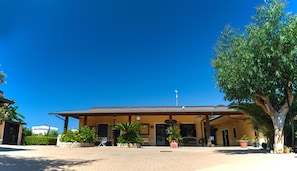 A building with a flat roof, a signboard, and a flagpole. - Villaggio Riviera Calabra (Zambrone)