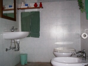 A bathroom with two sinks, a toilet, a mirror, and a trash bin. - Podere Il Caggio Appartements (San Gimignano)
