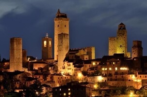 Un paisaje urbano histórico con arquitectura medieval, que incluye torres y murallas.