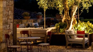 An outdoor seating area with stone walls, a table, and chairs. - Castello di Tornano (Gaiole in Chianti)