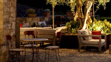 An outdoor seating area with stone walls, a table, and chairs.