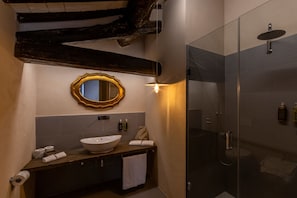 A bathroom with a wooden vanity, a large mirror, a round sink, and a glass-enclosed shower. - Castello di Tornano (Gaiole in Chianti)