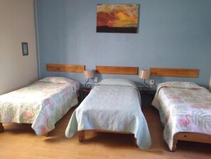A room with three single beds, each with a wooden headboard and a patterned bedspread. - Hostal Don Felipe  (Guadalajara)