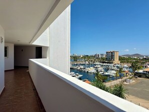 Ein Balkon mit Blick auf einen Jachthafen und Gebäude in der Ferne.