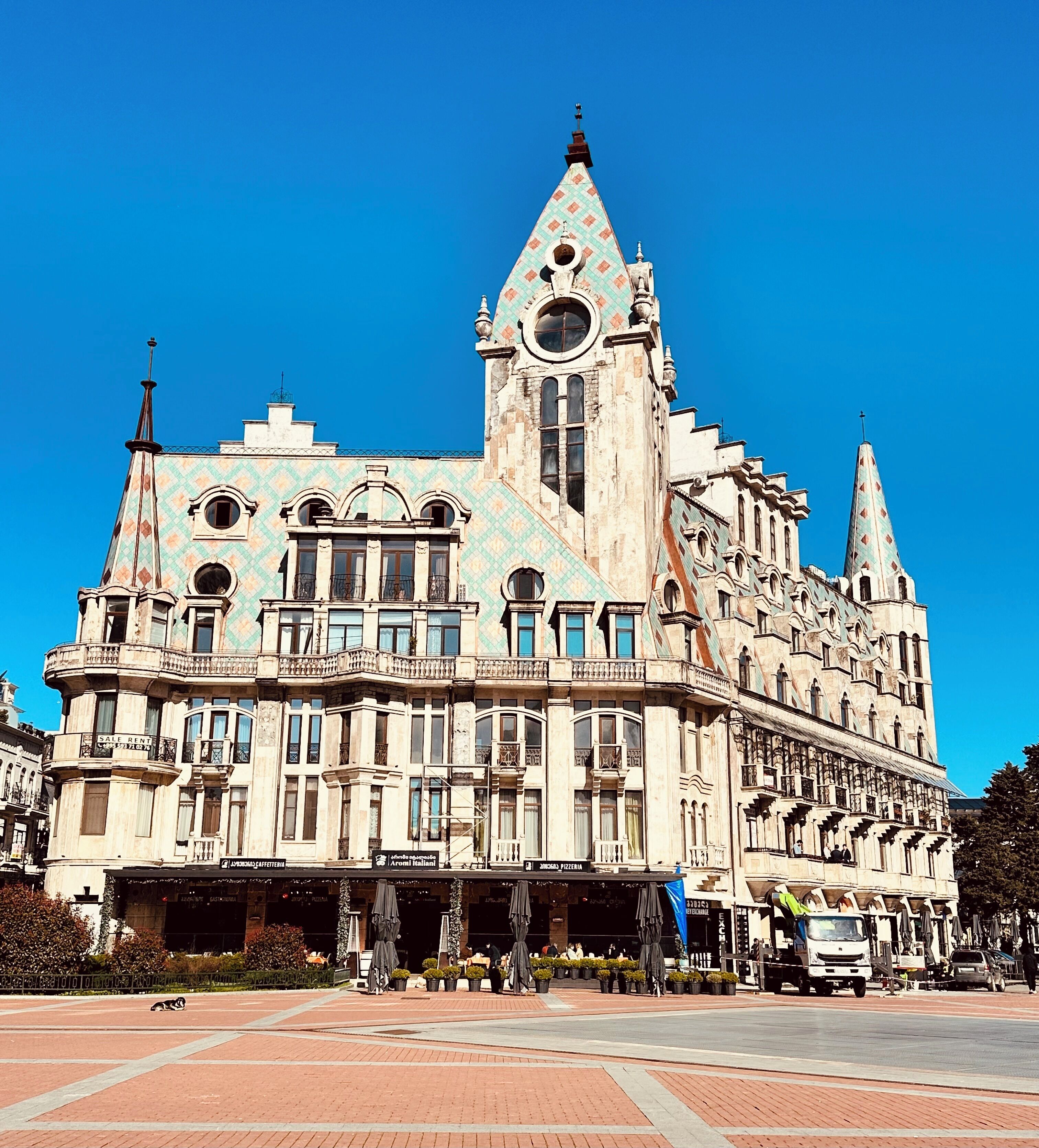 A historic building with a prominent tower, multiple windows, and a central entrance.