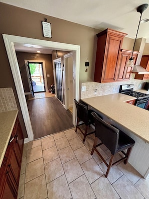 A kitchen with a large island, dark wood cabinets, and a view into the dining area.