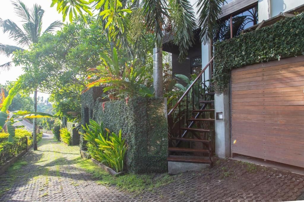 Un sendero que lleva a una casa con una escalera de madera y una entrada portón.